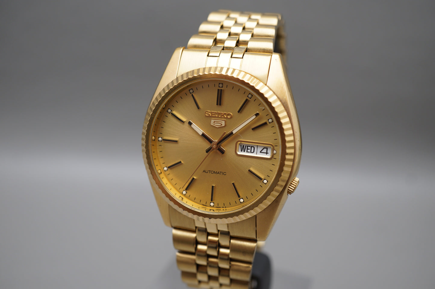 Seiko 5 Sports SNXJ94 7S26 Gold Tone Fluted Bezel Day Date Automatic Watch