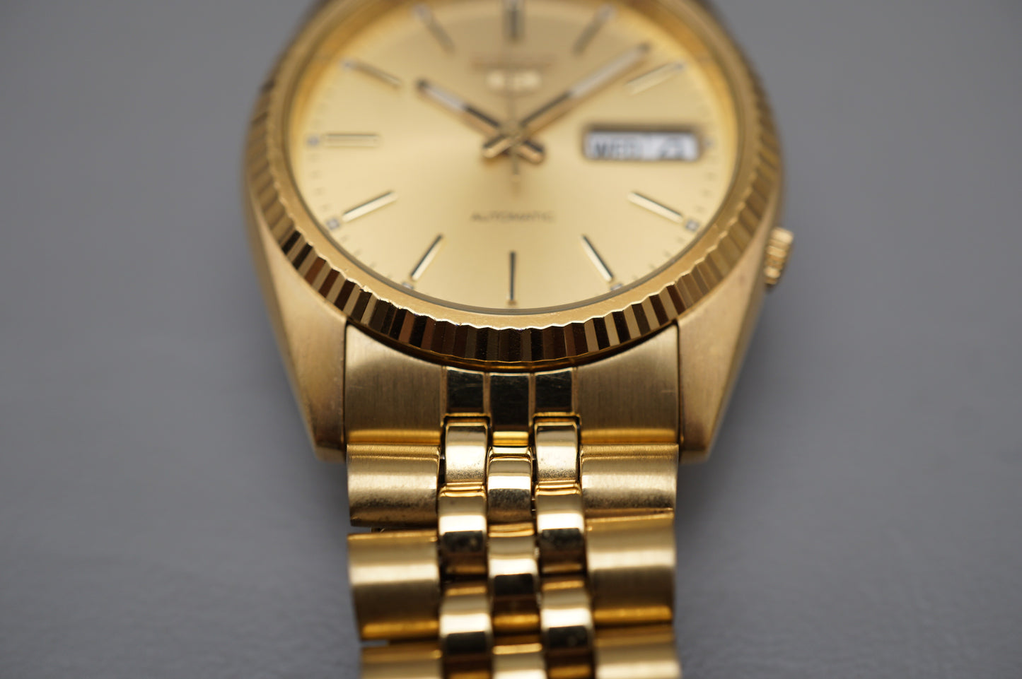Seiko 5 Sports SNXJ94 7S26 Gold Tone Fluted Bezel Day Date Automatic Watch