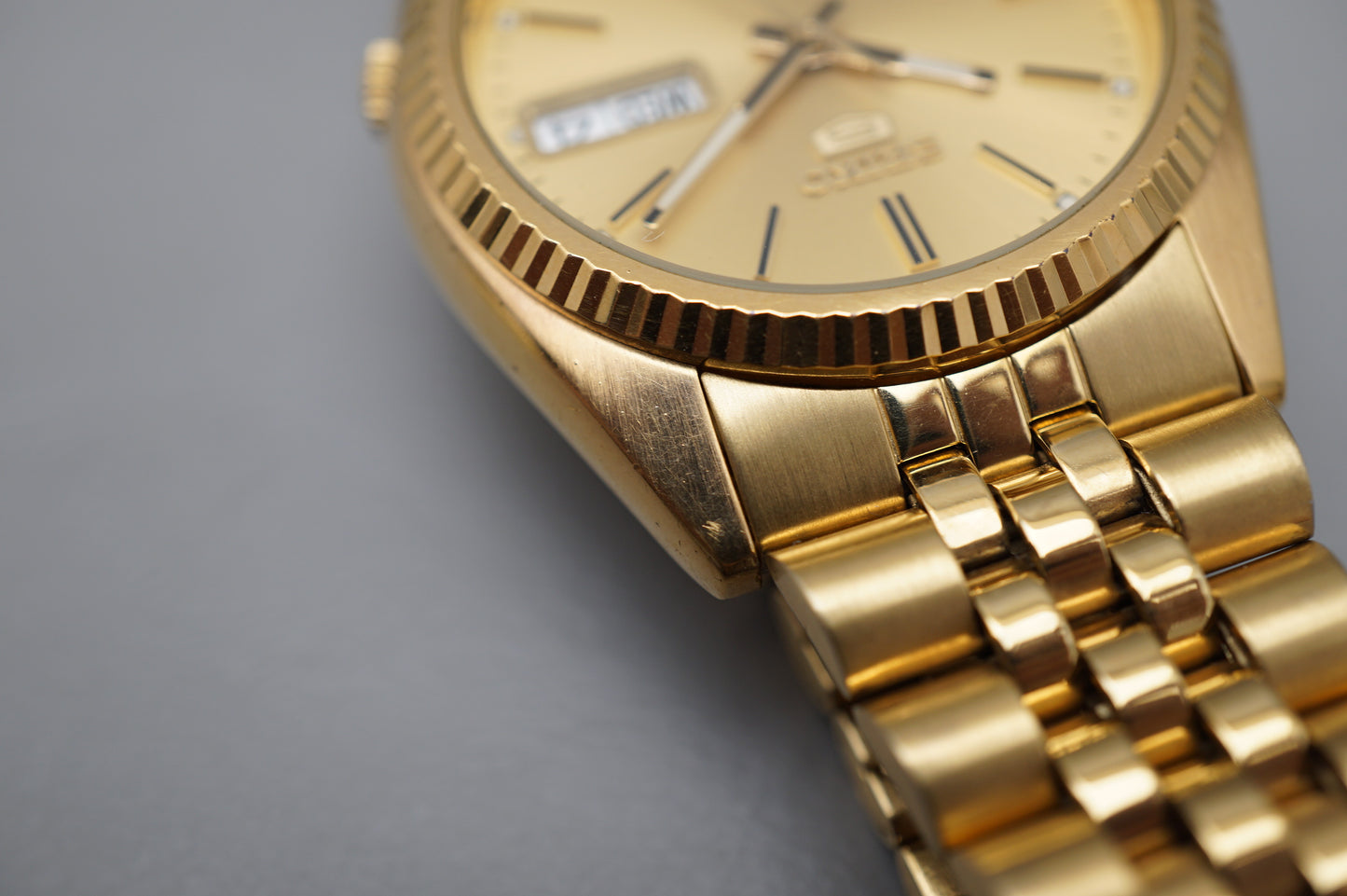 Seiko 5 Sports SNXJ94 7S26 Gold Tone Fluted Bezel Day Date Automatic Watch